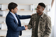 Cheerful guy in suit shaking black military man hand, a Photo by Prostock-Studio (Thumbnail 3 of 5)