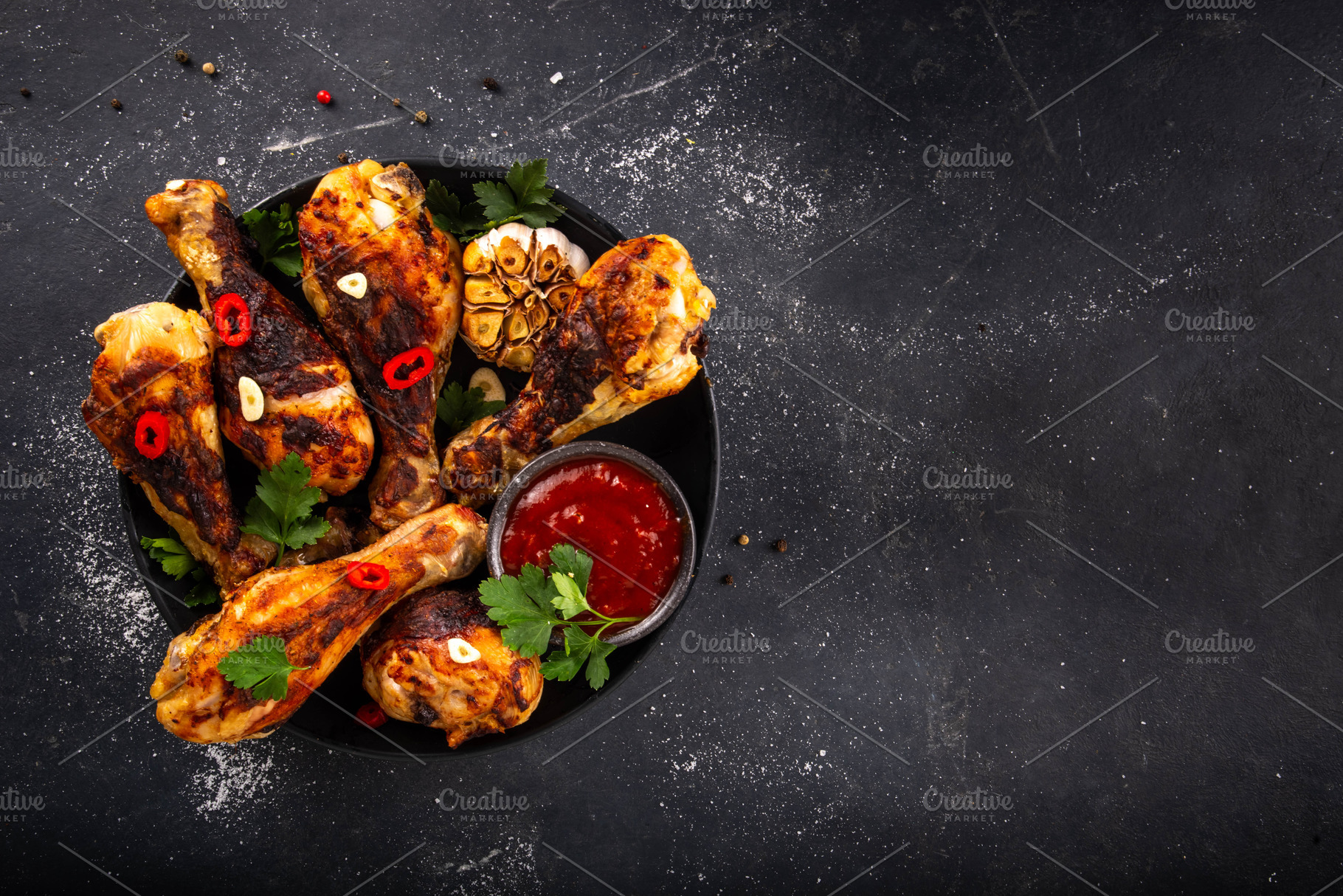 Grilled chicken legs with garlic, spices, parsley, bbq sauce and, a Food & Drink Photo by Rimma