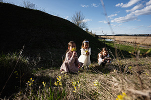 Three young girls picking wildflowers in a sunny spring meadow near a river, pl, a Person Photo by AS photostudio