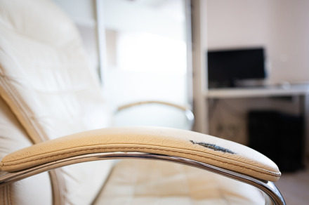 Close up of a scratched modern leather armchair in the living ro, a Photo by AS photostudio