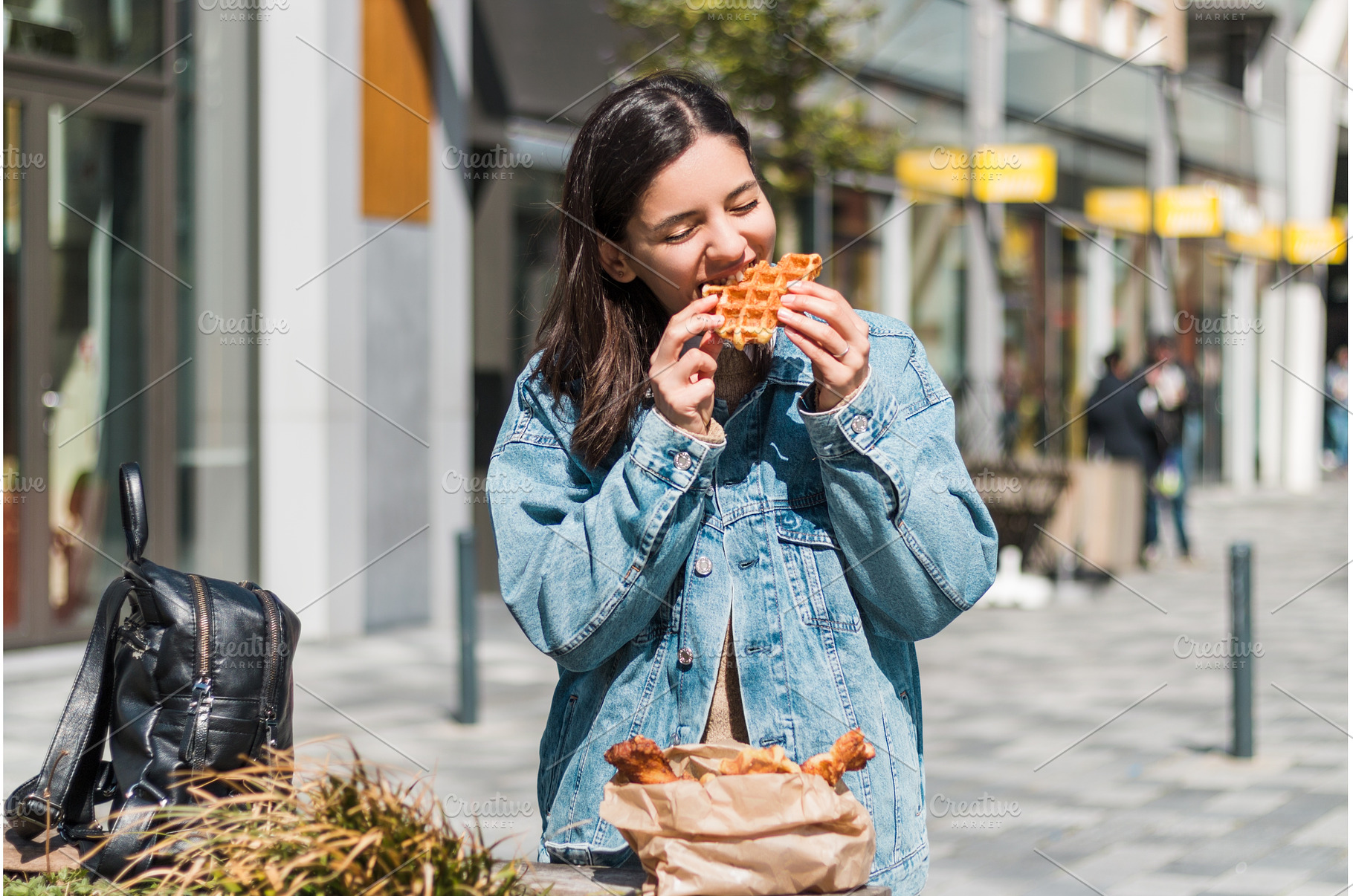 Woman in her 20s takes a bite of a, a Person Photo by AD Stock Images