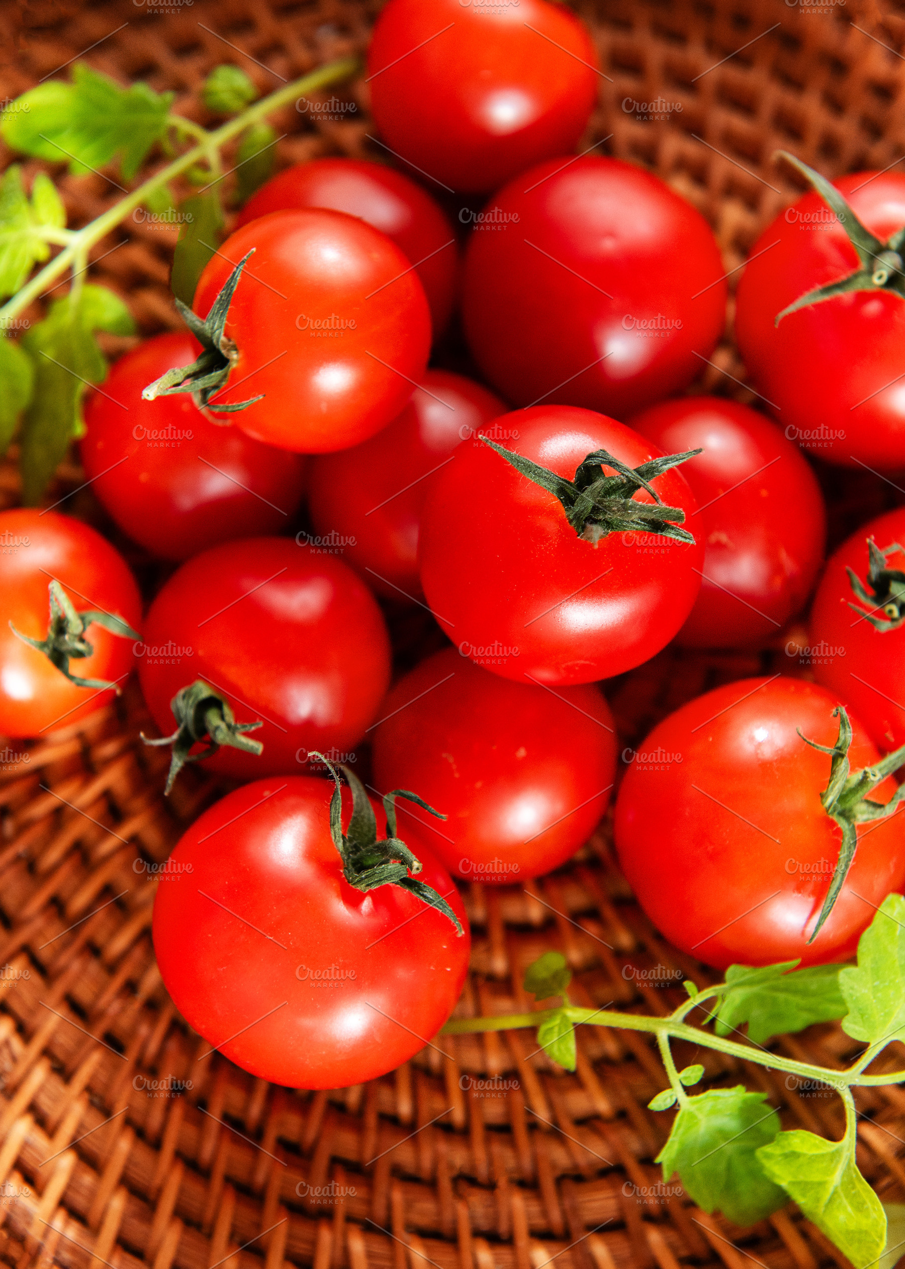 Cherry tomatoes resting in rustic wicker basket, a Food & Drink Photo by Olena Rudo