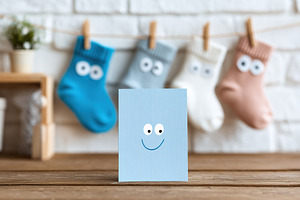 Unique greeting card design featuring a cheerful face among colorful socks on a, a Beauty & Fashion Photo by AlyaAnd