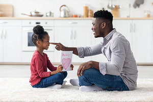 Cute little girl greeting her daddy with Fathers Day, a Photo by Prostock-Studio
