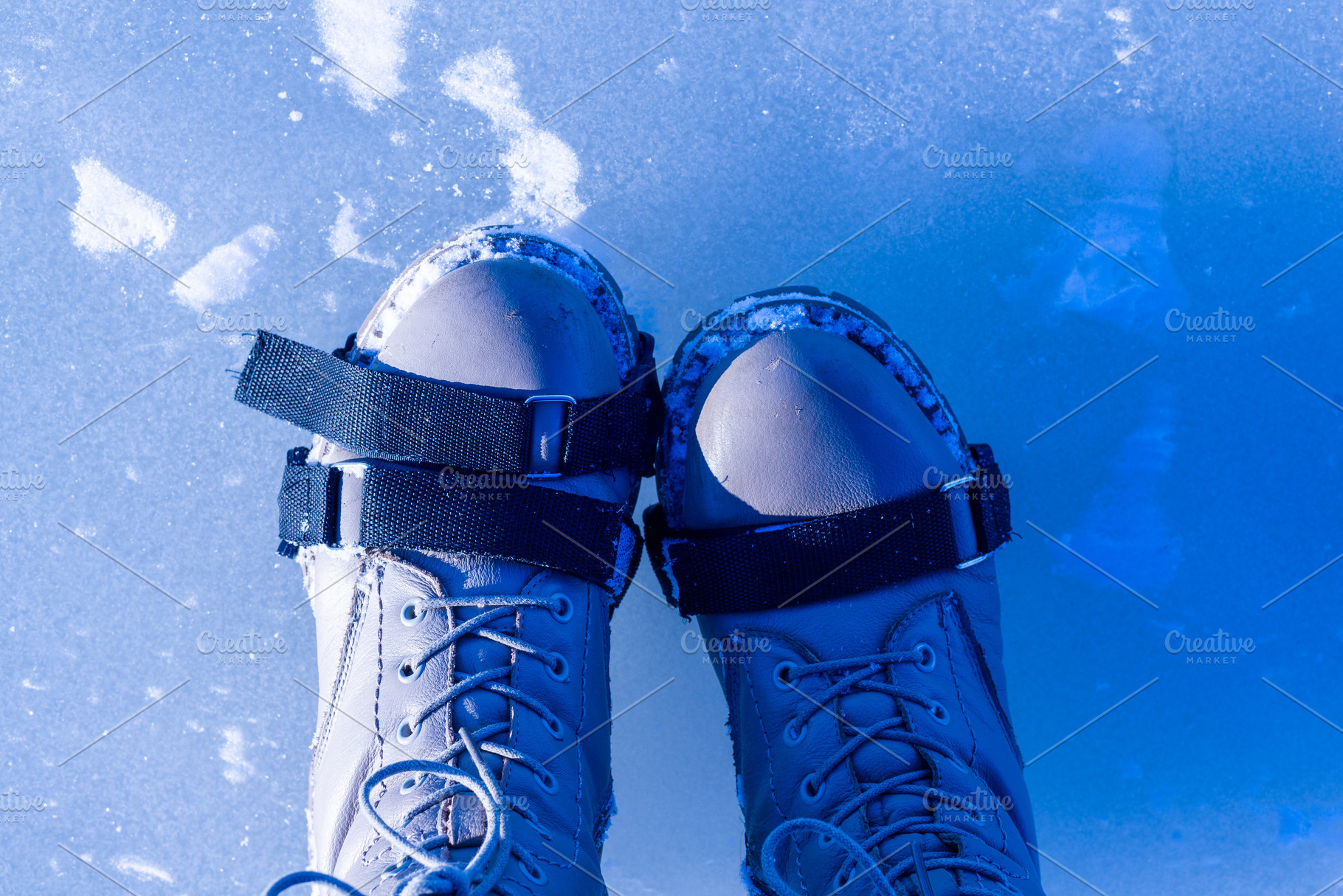 Top view of boots with ice cleats on frozen icy surface, a Photo by MDBildes