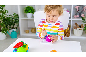 Child plays kitchen and food toys, a Person Photo by yanadjana