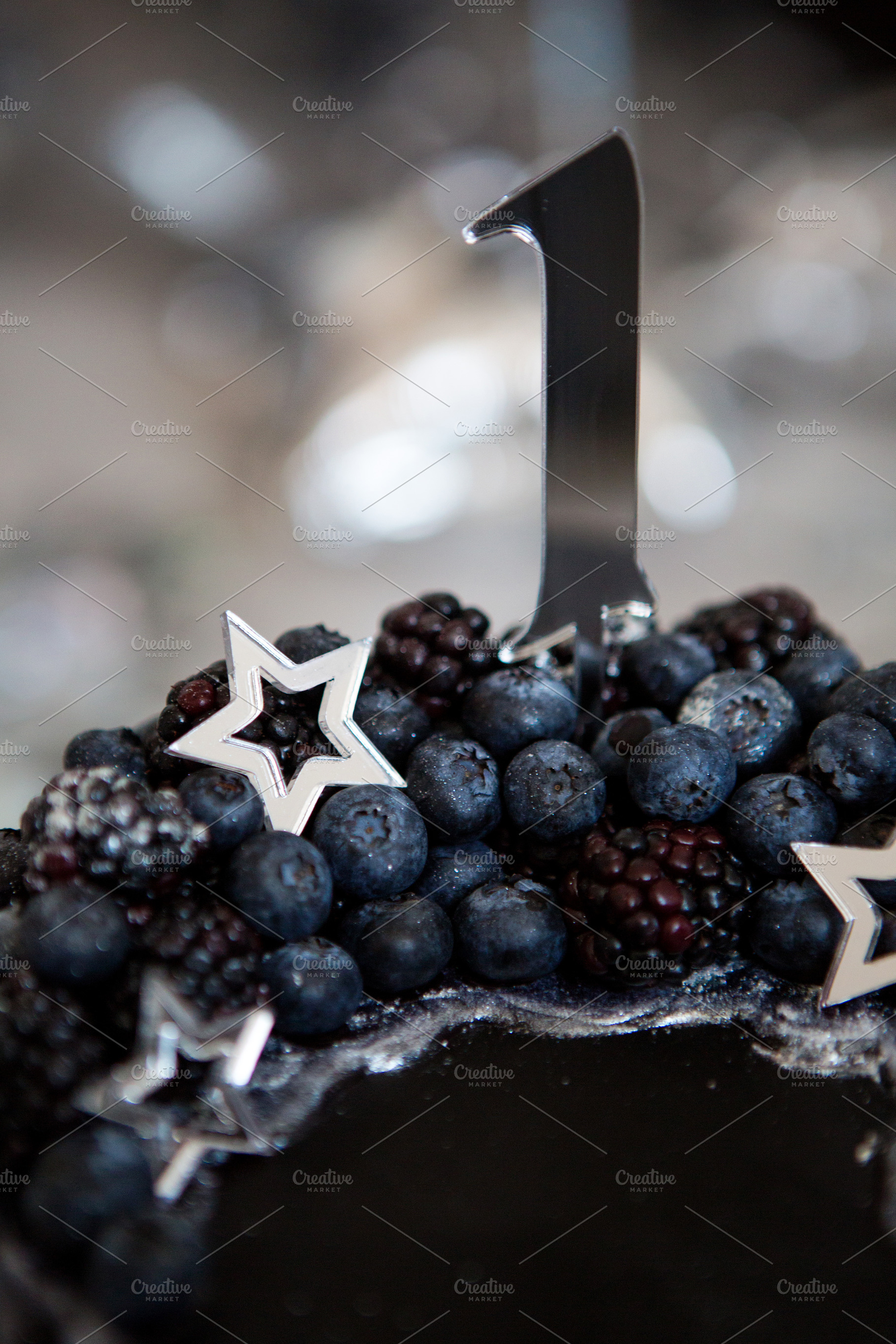 Black cake with stars and berries containing black, cake, and berry, a Food & Drink Photo by SaulichPhoto