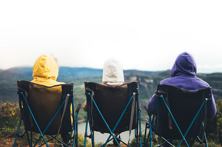 Three friends sit in camping chairs stock photo containing friends and nature