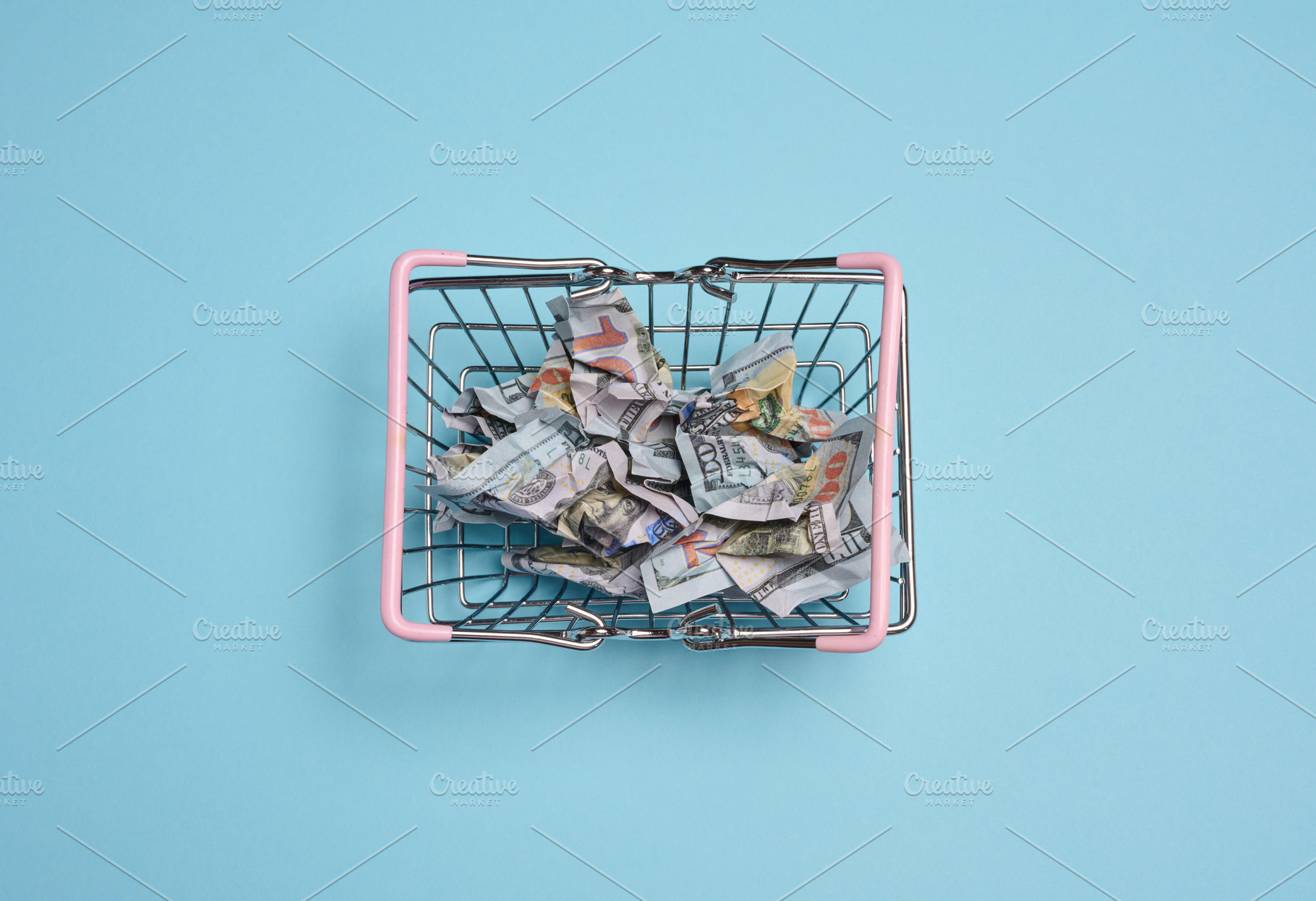 A metal shopping basket with pink handles filled with crumpled d, a Business Photo by ndanko
