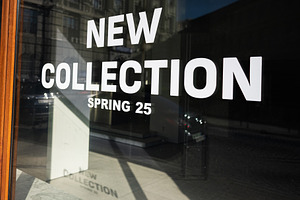 Modern storefront showcasing spring fashion 2025 with reflective city backgroun, a Photo by AS photostudio