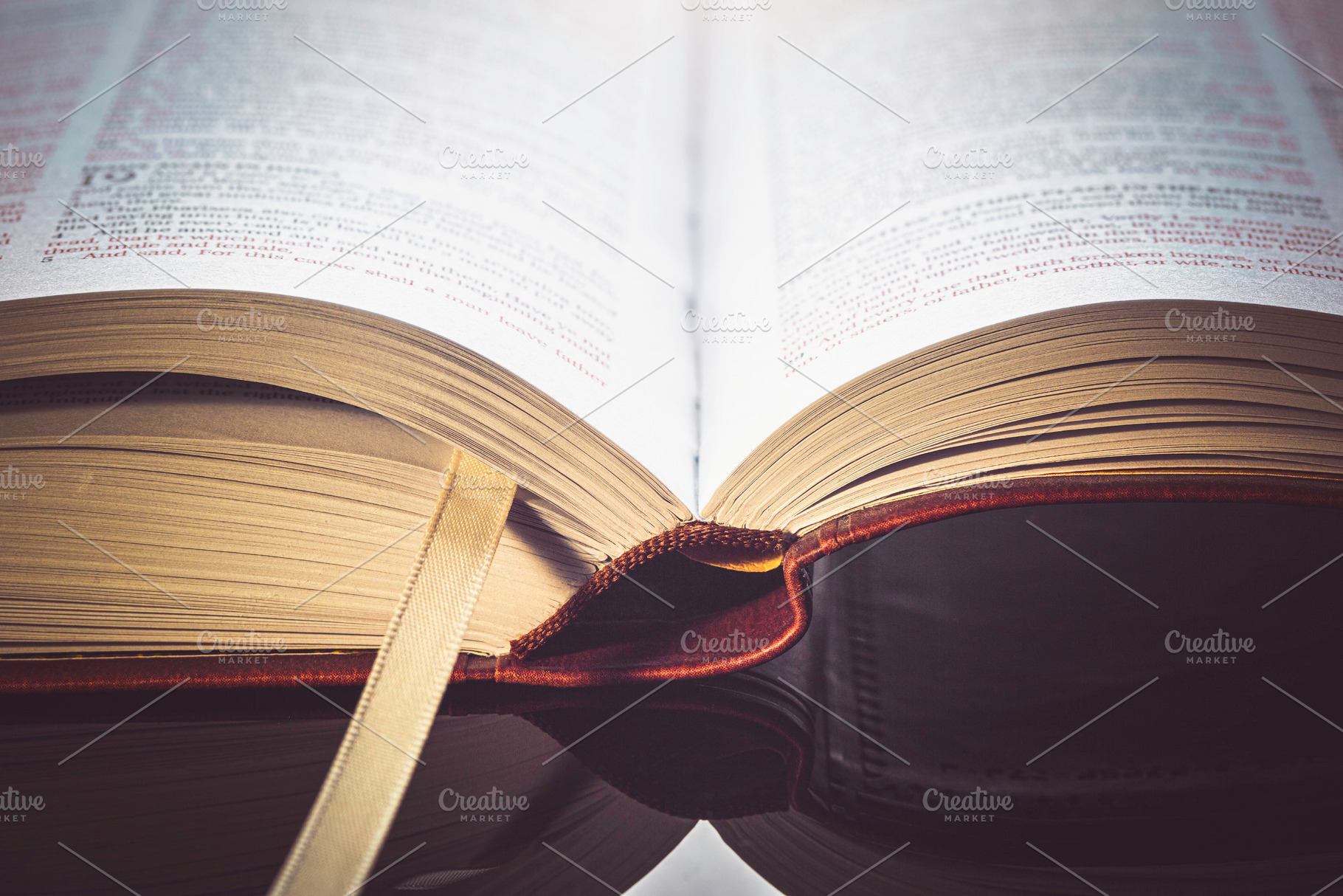 Open Bible on top of a glass desk., a Photo by Javier Art Photography