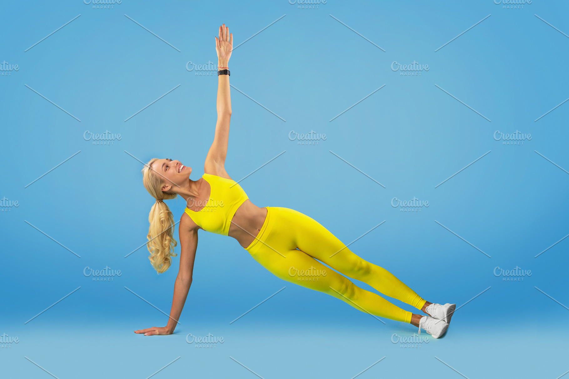 Smiling Young Woman Doing Side Plank Balance Exercise, a Photo by Prostock-Studio