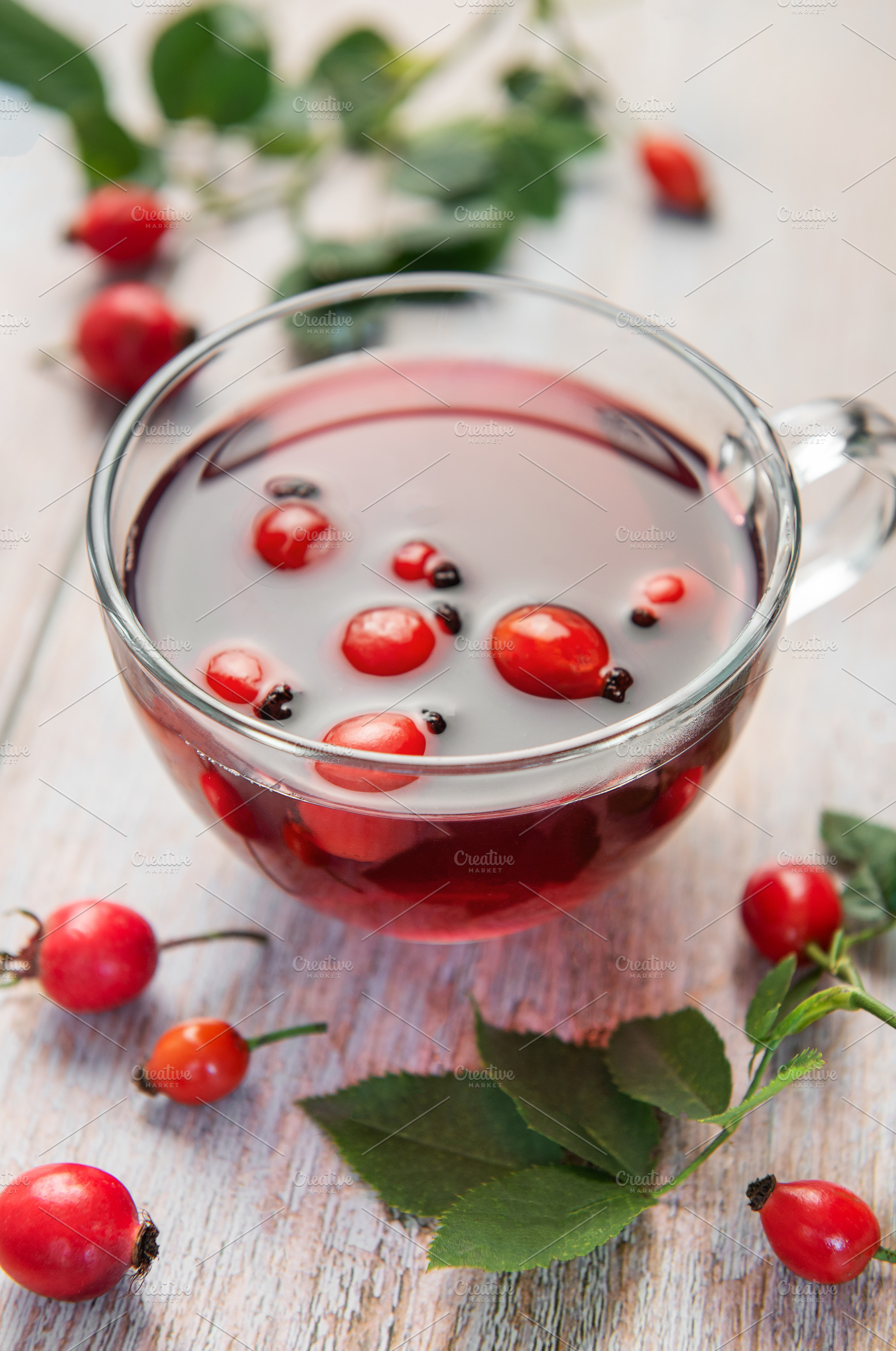 Rosehip tea brewing in glass cup on rustic wooden table, a Food & Drink Photo by Olena Rudo