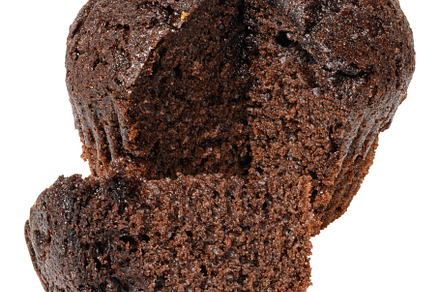 A partially cut dark chocolate muffin or cupcake, revealing its