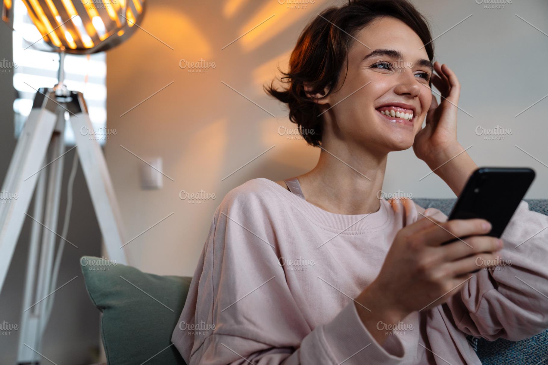 Smiling attractive young woman using mobile phone, a Person Photo by Dean Drobot