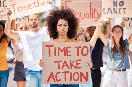 Protest, poster and black woman, crowd or equality, human rights or racism protesters in city. Activism, action time or angry group demand freedom, end to racial discrimination or government change., a Photo by Peopleimages.com