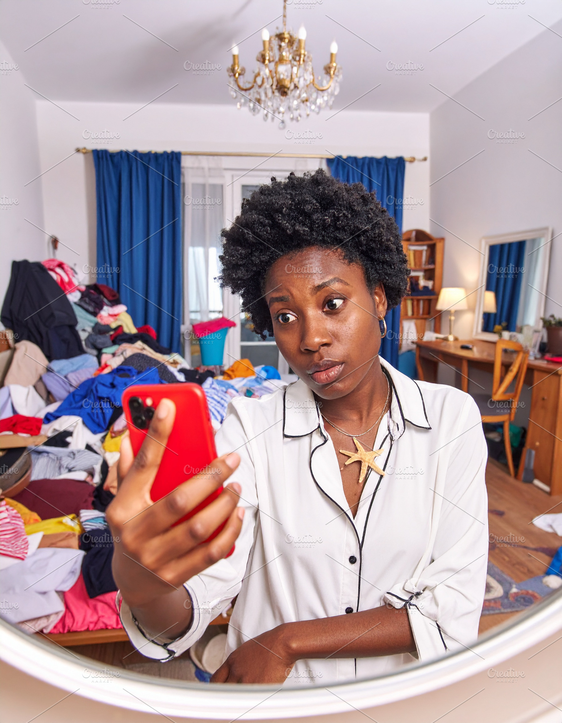 Young woman holding a phone takes a mirror selfie in a cluttered, a Person Photo by DanFLCreativo