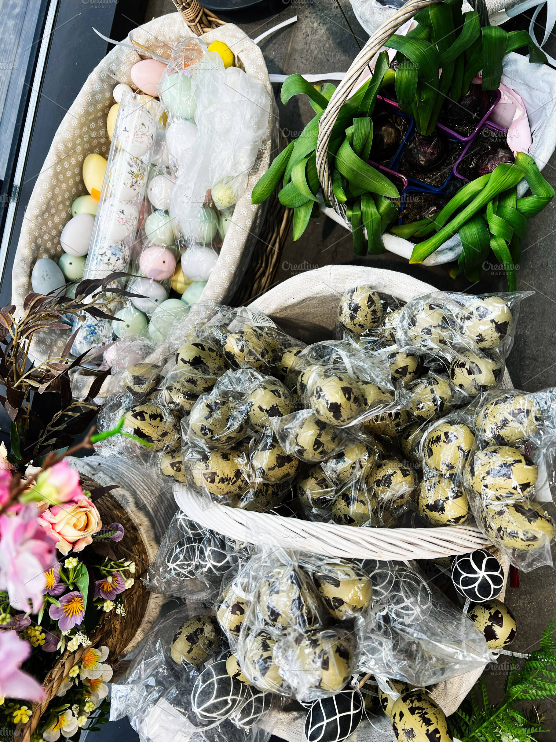 Colorful baskets of eggs with flowers and plants on a table, a Photo by AS photostudio