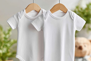 Two white baby clothes on hangers, a Beauty & Fashion Photo by AlyaAnd