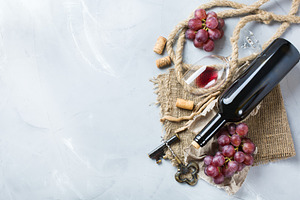 Bottle corkscrew glass of red wine grapes on a table stock photo containing