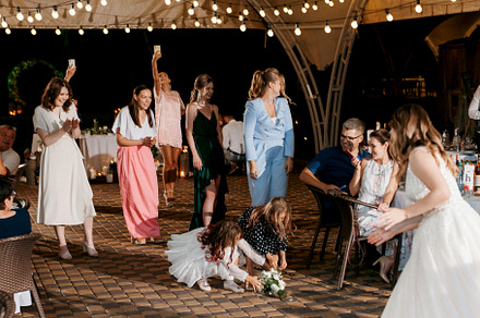 bride in a white dress throws a wedding bouquet