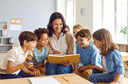 Teacher with a small group of children in a classroom pointing a, a School & Education Photo by DanFLCreativo