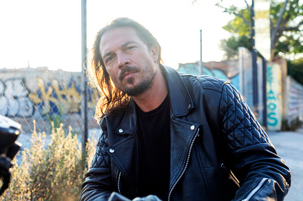 Young male on a chopper motorcycle while looking camera, a Person Photo by 2Design