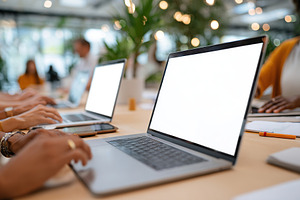 Collaborative workspace with laptops and people engaged in productive activitie, a Photo by AlyaAnd