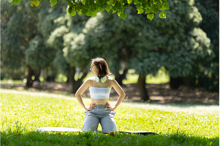 A woman is sitting on the grass in a