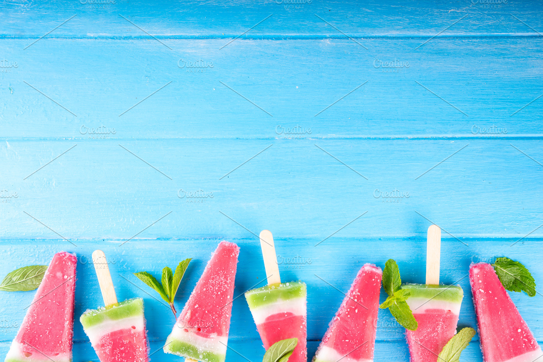 Tasty sweet watermelon ice cream lollies on blue wooden table, a Food & Drink Photo by Rimma