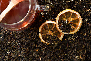 Cup of black tea and lemon on dried tea leaves, a Food & Drink Photo by Davizro's Market