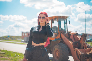Confident red haired woman in sunglasses posing near industrial, a Photo by Pictures for you!!!!!!!!!