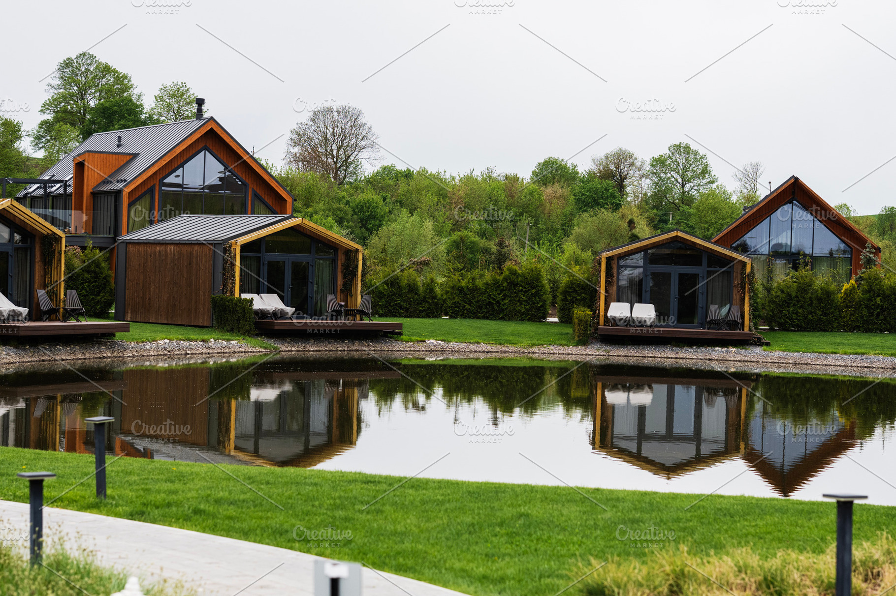 Modern wooden cabins by a serene lake surrounded by greenery and tranquility, a Photo by AS photostudio