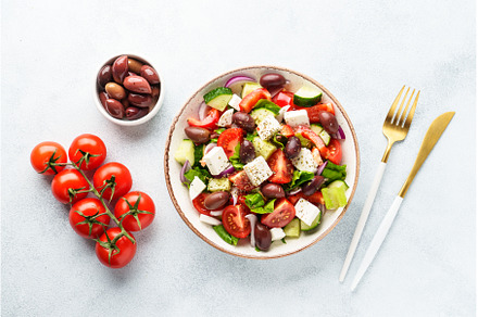 Greek salad in craft plate on white