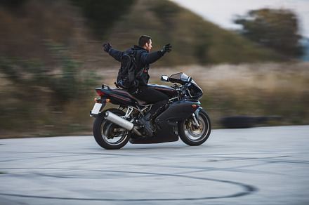 Young biker riding a sport motorbike without hands and feel free