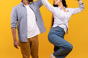 Affectionate indian couple holding hands and dancing together over yellow backg, a Photo by Prostock-Studio (Thumbnail 1 of 2)