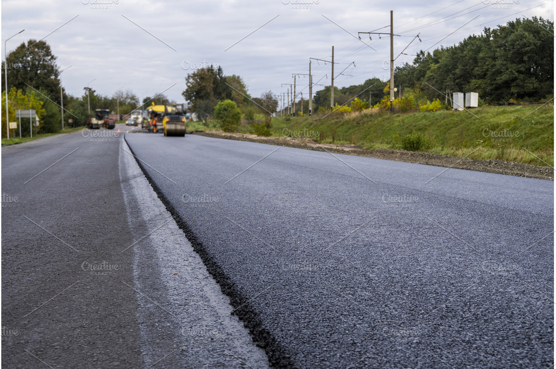 Freshly paved asphalt road with, an Industrial Photo by volodymyrshtun13795
