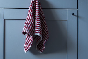 Kitchen cabinet door with a red and white striped towel hanging, an Industrial Photo by MDBildes