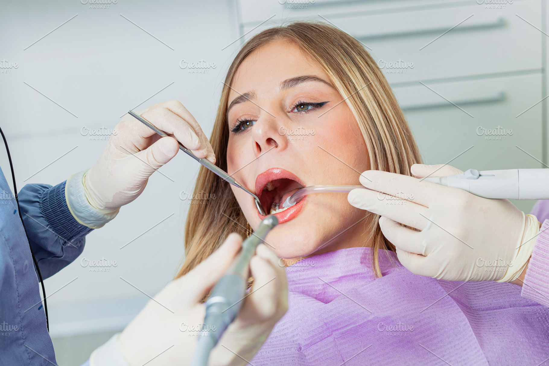 Dentist performing dental check up on young woman in clinic, a Health & Medical Photo by Antonio Gravante Market