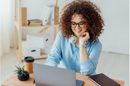 Young curly woman work on the, a Business Photo by Ksenia Neyman
