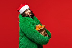 Woman in Santa hat and green coat, a Holiday Photo by Elena Vagengeim