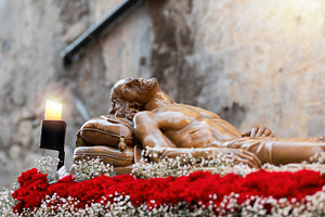 Wooden statue of Jesus Christ resting after crucifixion during Holy Week proces, a Holiday Photo by Antonio Gravante Market
