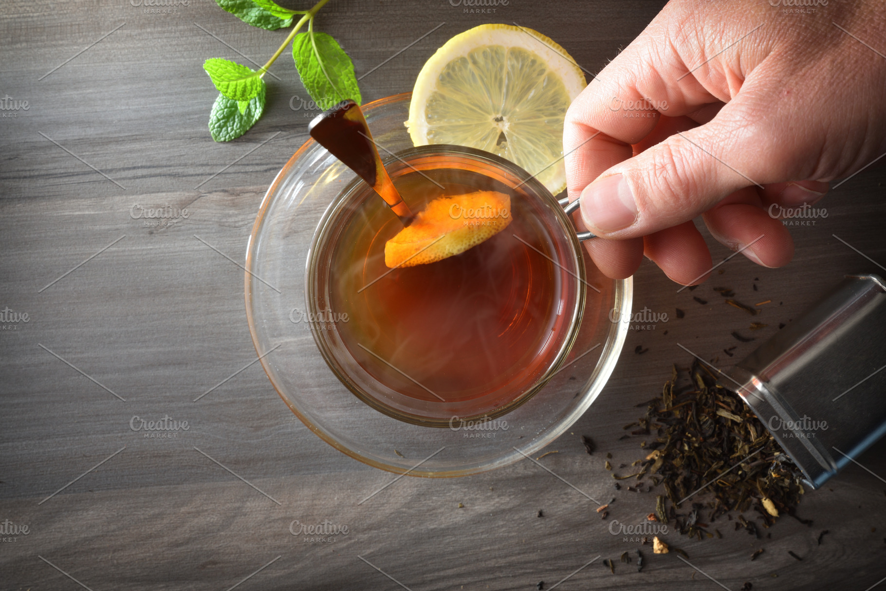 Person holding a cup of hot tea on dark table, a Food & Drink Photo by Davizro's Market