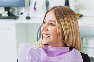 Young woman smiling while sitting on dentist chair, a Health & Medical Photo by Antonio Gravante Market
