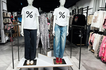 Two mannequins wearing casual clothing in a modern retail fashion store display, a Photo by AS photostudio