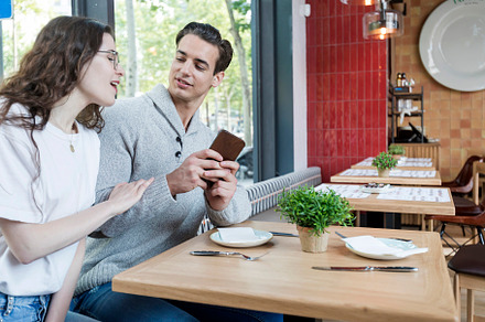 Best friends at coffee shop looking at smart phone, a Person Photo by RF Images