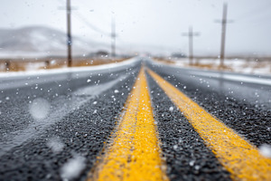 Snowy road with yellow lane, a Transportation Photo by MistyDay