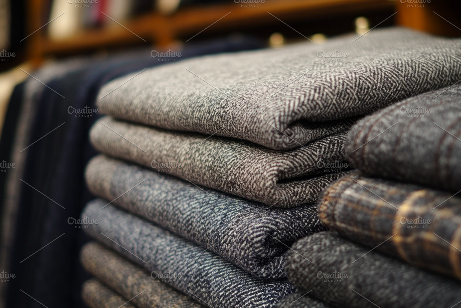 Neatly folded stacks of textured fabric in various shades of gray, showcasing c, a Background Photo by ImageMir