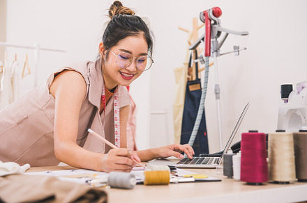 Attractive Asian female fashion designer working in home office, a Person Photo by Ministocker