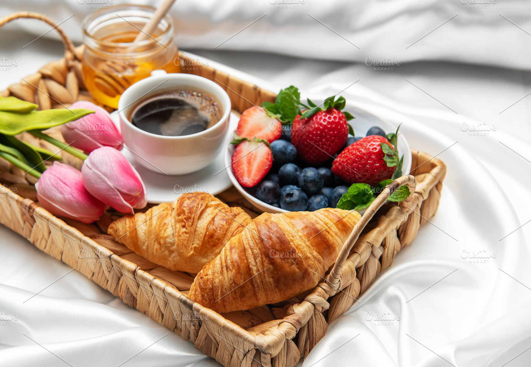 Romantic breakfast in bed with coffee, croissants, berries, hone, a Food & Drink Photo by Olena Rudo